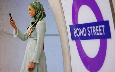 Person using mobile phone on the Elizabeth Line Bond Street station platform