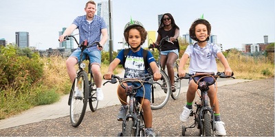 A family on bicycles cycling through a park